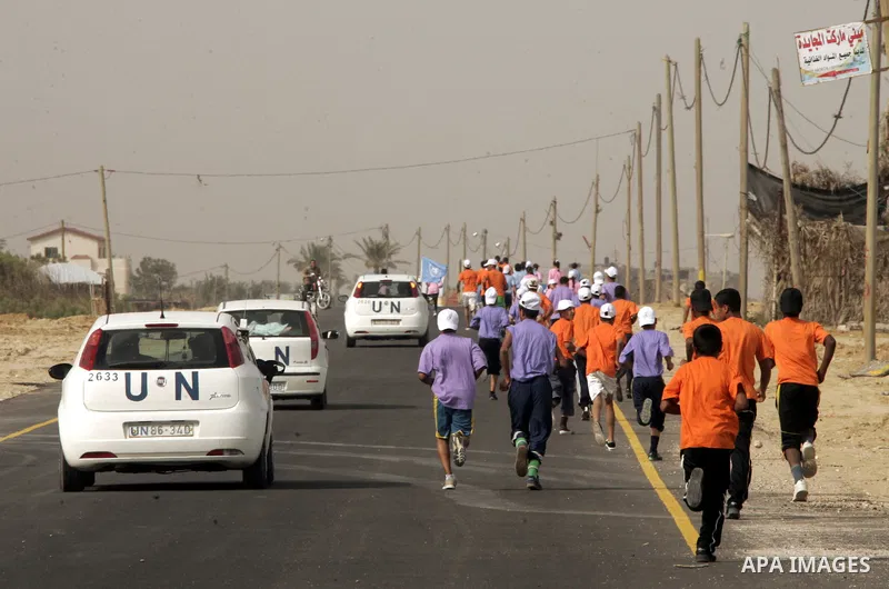 UN vehicles escort Palestinian and foreign participants running in Rafah town in the southern Gaza Strip on May 5, 2011 as they compete in the Gaza Strip's first-ever marathon which runs the entire length of the coastal...