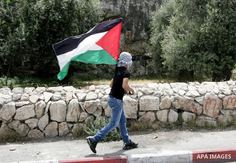 A masked Palestinian youth prepares to hurl stones toward Israeli soldiers during clashes in the flashpoint east Jerusalem neighbourhood of Silwan on May 6,2011. Photo by Mahfouz Abu Turk