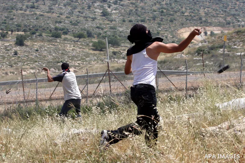 A Palestinian protestor hurls stones toward Israeli forces during a rally on May 6, 2011, in the Israeli-occupied West Bank village of Bilin, to protest against the Israeli occupation and to celebrate the political unity...