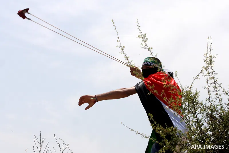 A Palestinian protestor hurls stones toward Israeli forces during a rally on May 6, 2011, in the Israeli-occupied West Bank village of Bilin, to protest against the Israeli occupation and to celebrate the political unity...