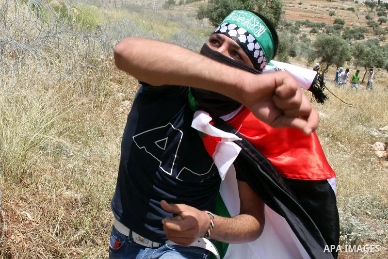 A Palestinian protestor hurls stones toward Israeli forces during a rally on May 6, 2011, in the Israeli-occupied West Bank village of Bilin, to protest against the Israeli occupation and to celebrate the political unity...