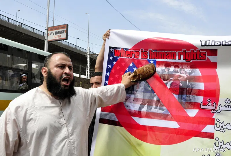 An Egyptian Islamist raises his shoe over a poster depicting American flag as he protests the killing of al-Qaida leader Osama Bin Laden, following the Friday prayer in the Nour mosque in Cairo, Egypt, Friday, May 6, 201...