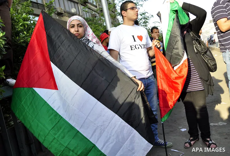 Egyptian protesters wave Palestinian flags and chant slogans outside the Israeli embassy in Cairo, Egypt, Friday, May 6, 2011, in support with Palestinians and against Israeli occupation. Photo by Ahmed Asad