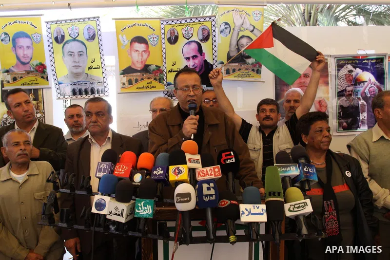 Palestinians Speak during a press conference, as women hold pictures of jailed relatives during a protest in Gaza city calling for their release from Israeli prisons on May 7, 2011. Photo by Mohamad Asad
