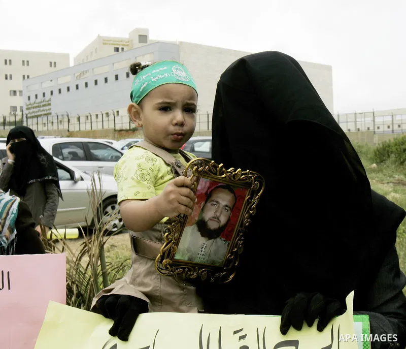 Palestinian women hamas holds a portrait of her relative who is held in jail in Jneid Prison ,during a demonstration in the West Bank city of Nablus for the release of Hamas prisoners from Palestinian jails. Saturday, Ma...
