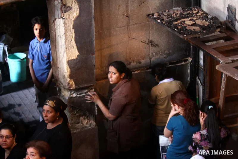 Egyptians Christians remove objects from the damaged Virgin Mary church in the popular area of Imbaba in the Egyptian capital of Cairo on May 8, 2011, after overnight clashes between Muslims and Christians which left 10...