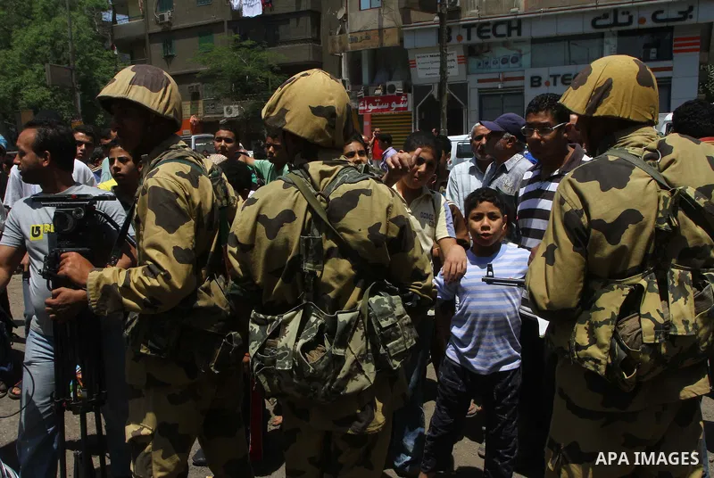 Egyptian military soldiers stand guard as Christians remove objects from the Virgin Mary church in the popular area of Imbaba in the Egyptian capital of Cairo on May 8, 2011 after clashes between Muslims and Christians w...