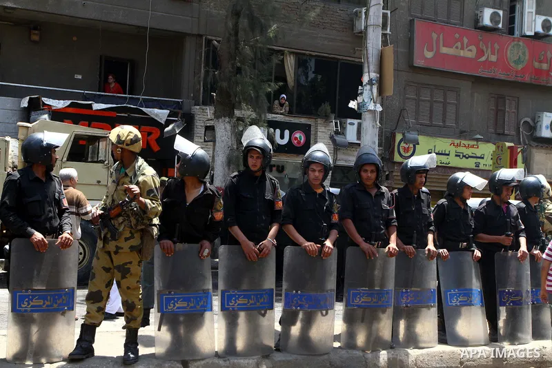 Egyptian military soldiers stand guard as Christians remove objects from the Virgin Mary church in the popular area of Imbaba in the Egyptian capital of Cairo on May 8, 2011 after clashes between Muslims and Christians w...