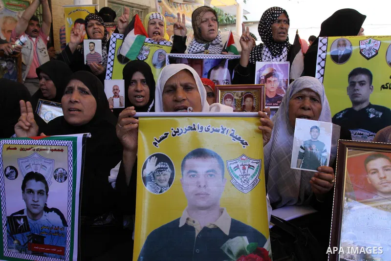 Palestinian women hold pictures of jailed relatives during a protest in Gaza city calling for their release from Israeli prisons at the headquarters of the International Red Cross in Gaza City May 9, 2011. Photo by Moham...