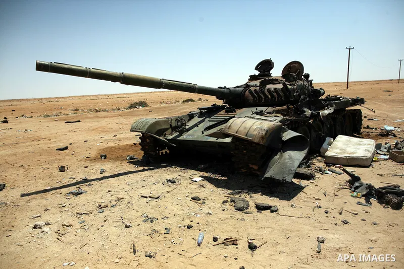 A burnt tank is seen as Libyan rebel fighters head towards the front line outside the Libyan eastern city Ajdabiya on May 10, 2011, where fighting between rebels and forces loyal to leader Moamer Kadhafi is ongoing. Phot...