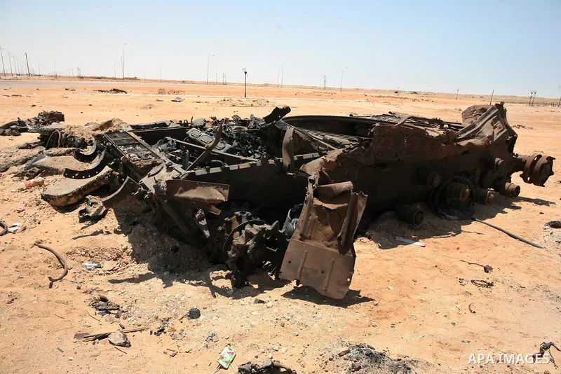 A burnt tank is seen as Libyan rebel fighters head towards the front line outside the Libyan eastern city Ajdabiya on May 10, 2011, where fighting between rebels and forces loyal to leader Moamer Kadhafi is ongoing. Phot...