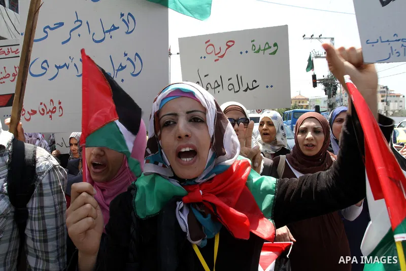 Palestinians hold their national flag and chant slogans during a rally in Gaza city on May 11,2011 calling Fatah and Hamas movements to unit and deal with reconciliation agreement. Photo by Mohammed Asad