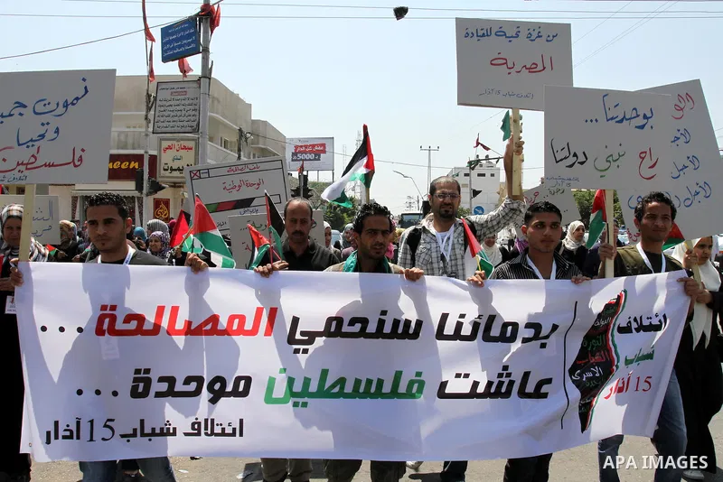 Palestinians hold their national flag and chant slogans during a rally in Gaza city on May 11,2011 calling Fatah and Hamas movements to unit and deal with reconciliation agreement. Photo by Mohammed Asad