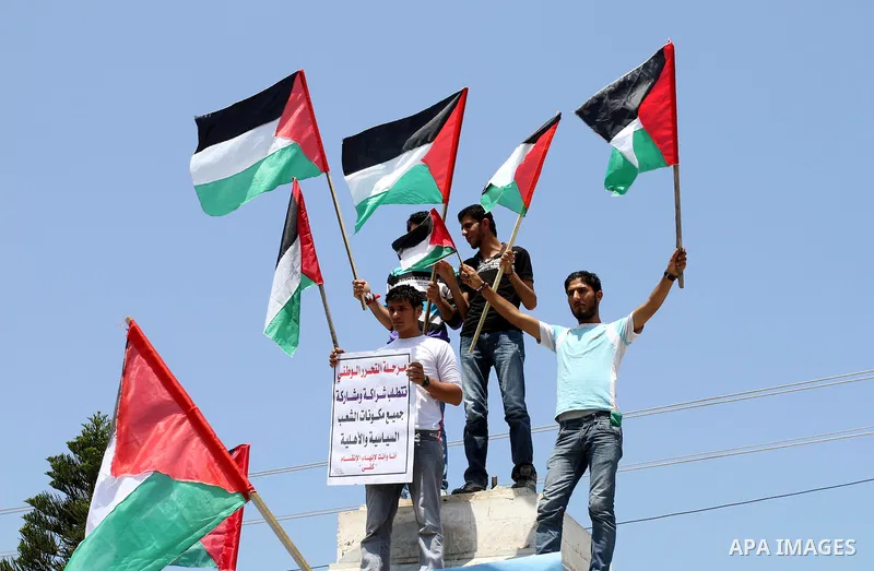 Palestinians hold their national flag and chant slogans during a rally in Gaza city on May 11,2011 calling Fatah and Hamas movements to unit and deal with reconciliation agreement. Photo by Mohammed Asad