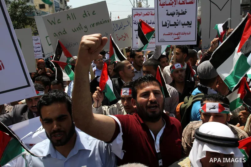 Palestinians hold their national flag and chant slogans during a rally in Gaza city on May 11,2011 calling Fatah and Hamas movements to unit and deal with reconciliation agreement. Photo by Mohammed Asad