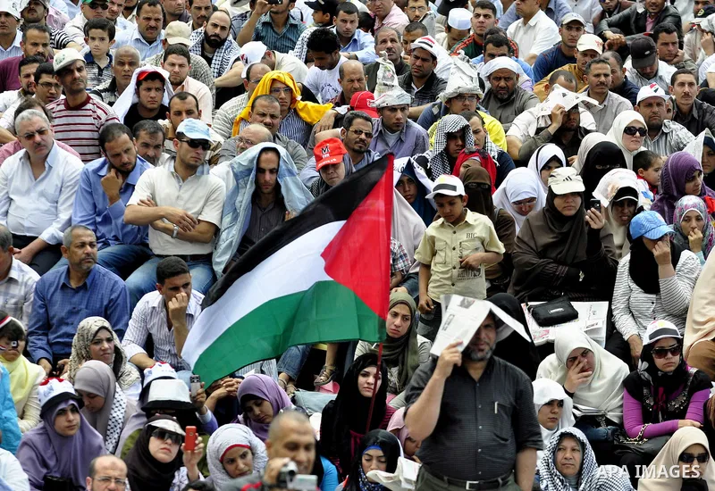 Egyptian demonstrators wave a Palestinian flag during a rally at Cairo's Tahrir Square on May 13, 2011 during a protest calling for national unity after attacks on Egyptian churches, and solidarity with the Palestinians...