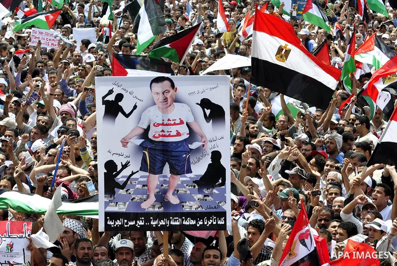 Egyptian demonstrators wave Palestinian flags and Egyptian flags during a rally at Cairo's Tahrir Square on May 13, 2011 during a protest calling for national unity after attacks on Egyptian churches, and solidarity with...