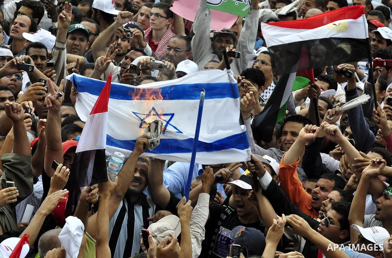 Egyptian demonstrators set fire in an Israeli flag during a rally at Cairo's Tahrir Square on May 13, 2011 during a protest calling for national unity after attacks on Egyptian churches, and solidarity with the Palestini...