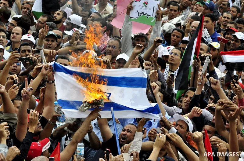 Egyptian demonstrators set fire in an Israeli flag during a rally at Cairo's Tahrir Square on May 13, 2011 during a protest calling for national unity after attacks on Egyptian churches, and solidarity with the Palestini...