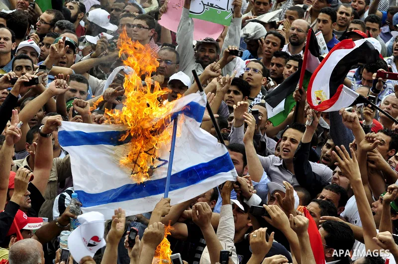 Egyptian demonstrators set fire in an Israeli flag during a rally at Cairo's Tahrir Square on May 13, 2011 during a protest calling for national unity after attacks on Egyptian churches, and solidarity with the Palestini...