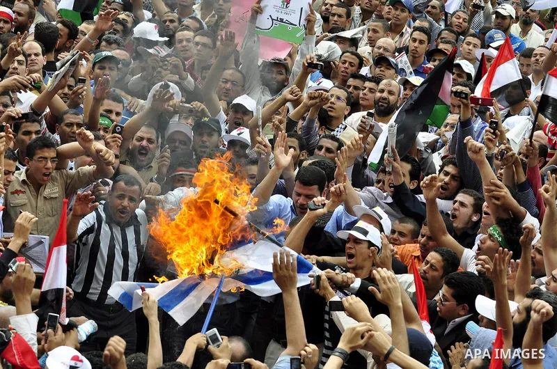 Egyptian demonstrators set fire in an Israeli flag during a rally at Cairo's Tahrir Square on May 13, 2011 during a protest calling for national unity after attacks on Egyptian churches, and solidarity with the Palestini...