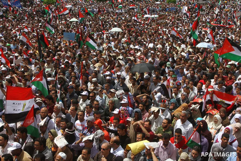 Egyptian demonstrators wave Palestinian flags and Egyptian flags during a rally at Cairo's Tahrir Square on May 13, 2011 during a protest calling for national unity after attacks on Egyptian churches, and solidarity with...