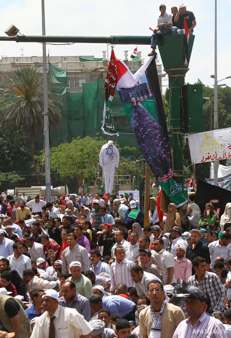 Egyptian demonstrators wave Palestinian flags and Egyptian flags during a rally at Cairo's Tahrir Square on May 13, 2011 during a protest calling for national unity after attacks on Egyptian churches, and solidarity with...
