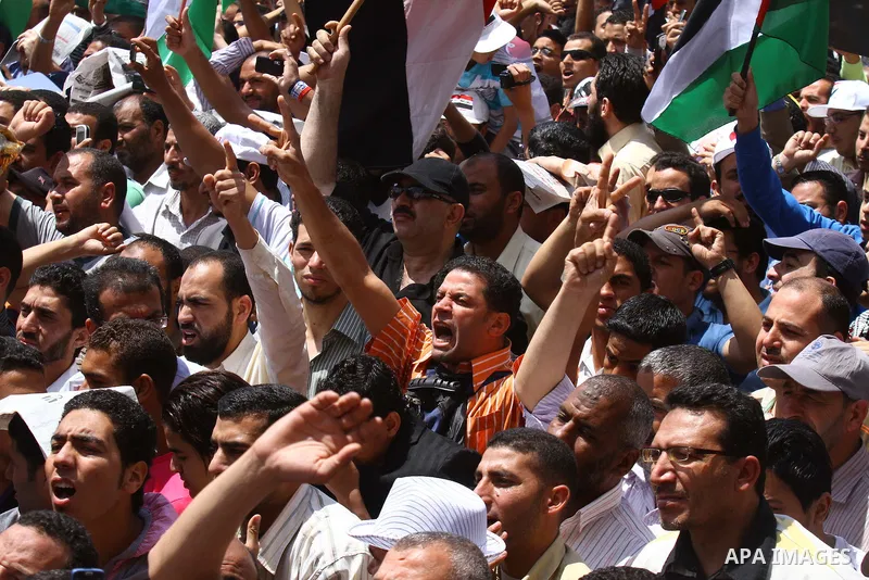 Egyptian demonstrators wave Palestinian flags and Egyptian flags during a rally at Cairo's Tahrir Square on May 13, 2011 during a protest calling for national unity after attacks on Egyptian churches, and solidarity with...
