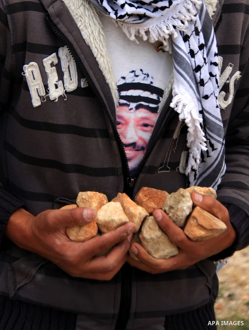 A Palestinian youth holds stones to be thrown at Israeli forces during a protest against Israel's controversial separation barrier and to mark the 63th anniversary of "Nakba" (catastrophe) on May 13, 2011in the West Bank...