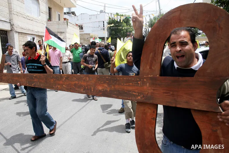 Palestinian protestors carry a big makeshift key during a protest against Israel's controversial separation barrier and to mark the 63th anniversary of "Nakba" (catastrophe) on May 13, 2011in the West Bank village of Bil...
