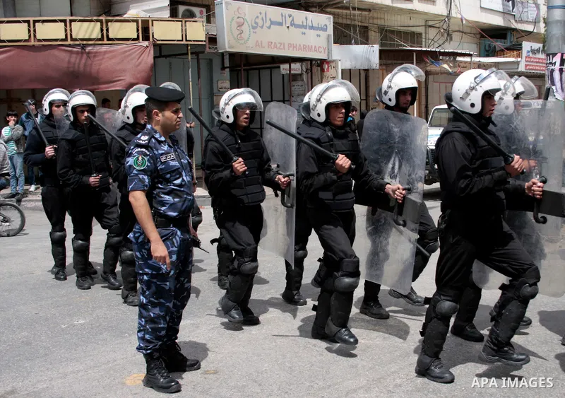 Palestinian security forces block the way of Hamas demonstrators who were trying to reach an Israeli-controlled checkpoint in the West Bank city of Hebron following a rally to mark the 63th anniversary of "Nakba" (catast...