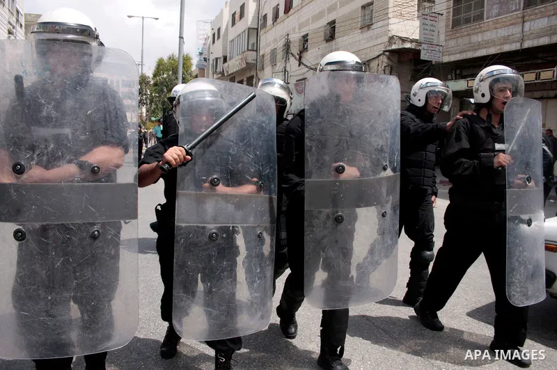 Palestinian security forces block the way of Hamas demonstrators who were trying to reach an Israeli-controlled checkpoint in the West Bank city of Hebron following a rally to mark the 63th anniversary of "Nakba" (catast...