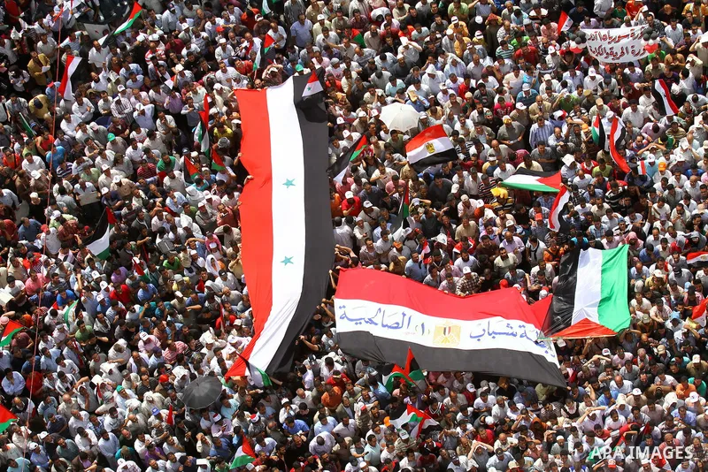 Egyptian demonstrators wave Palestinian flags and Egyptian flags during a rally at Cairo's Tahrir Square on May 13, 2011 during a protest calling for national unity after attacks on Egyptian churches, and solidarity with...