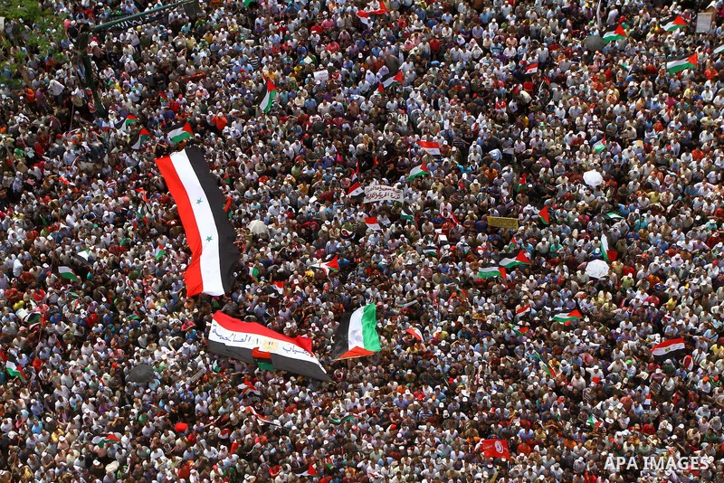 Egyptian demonstrators wave Palestinian flags and Egyptian flags during a rally at Cairo's Tahrir Square on May 13, 2011 during a protest calling for national unity after attacks on Egyptian churches, and solidarity with...