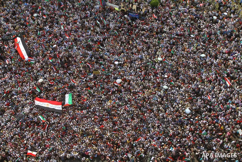 Egyptian demonstrators wave Palestinian flags and Egyptian flags during a rally at Cairo's Tahrir Square on May 13, 2011 during a protest calling for national unity after attacks on Egyptian churches, and solidarity with...