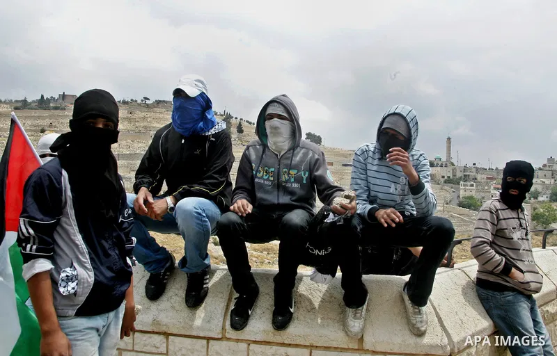 Palestinian youths prepare to hurl stones during clashes following the funeral of a teenager who died after being shot as Palestinians launched events to mourn the 1948 creation of the Jewish state in Jerusalem the day b...