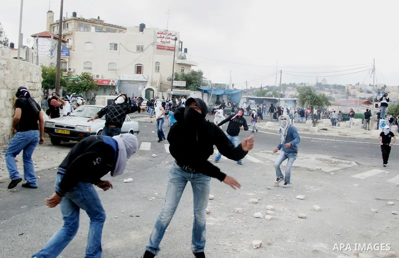Palestinian youths throw stones during clashes following the funeral of a teenager who died after being shot as Palestinians launched events to mourn the 1948 creation of the Jewish state in Jerusalem the day before, aft...