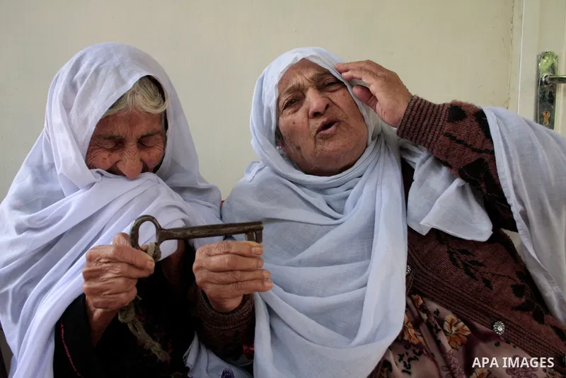 Palestinian refugees sit and holding a key in the Al-Aroub refugee camp near Hebron, on May 14 , 2011 after they was expelled from there original home in 1948. Palestinians commemorate the 63rd anniversary of Nakba, or c...