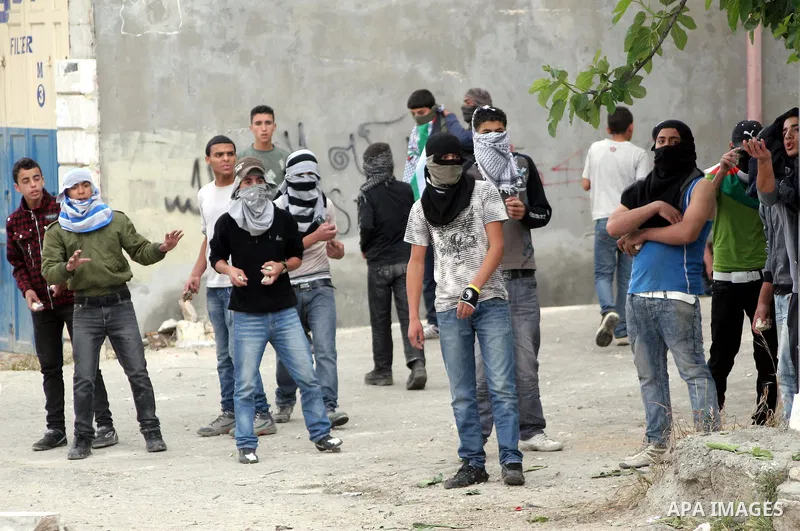 Palestinian youths throw stones at Israeli soldiers during confrontations in the West Bank city of Hebron, while Palestinians mourned on May 15, 2011 the "nakbah" anniversary of Israel's creation in 1948, as a result of...