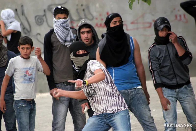 Palestinian youths throw stones at Israeli soldiers during confrontations in the West Bank city of Hebron, while Palestinians mourned on May 15, 2011 the "nakbah" anniversary of Israel's creation in 1948, as a result of...