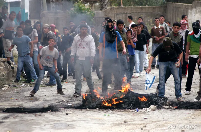 Palestinian youths throw stones at Israeli soldiers during confrontations in the West Bank city of Hebron, while Palestinians mourned on May 15, 2011 the "nakbah" anniversary of Israel's creation in 1948, as a result of...