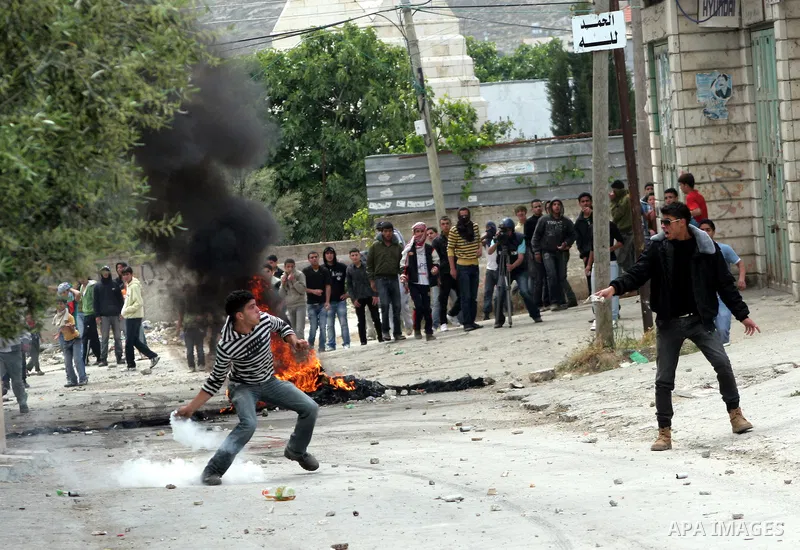 Palestinian youths throw stones at Israeli soldiers during confrontations in the West Bank city of Hebron, while Palestinians mourned on May 15, 2011 the "nakbah" anniversary of Israel's creation in 1948, as a result of...