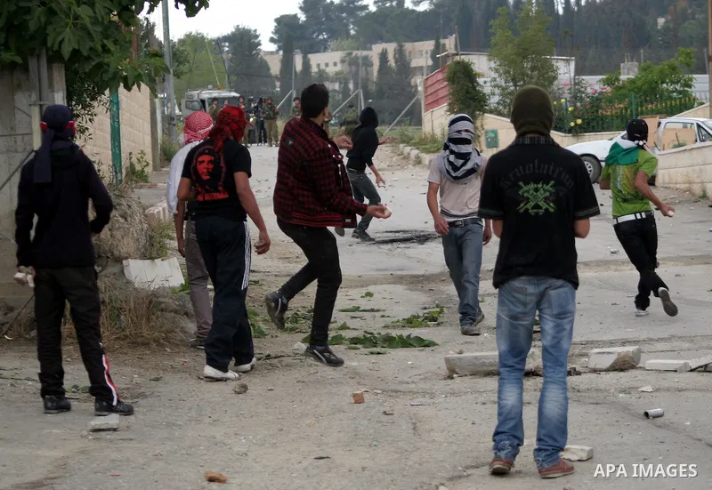 Palestinian youths throw stones at Israeli soldiers during confrontations in the West Bank city of Hebron, while Palestinians mourned on May 15, 2011 the "nakbah" anniversary of Israel's creation in 1948, as a result of...
