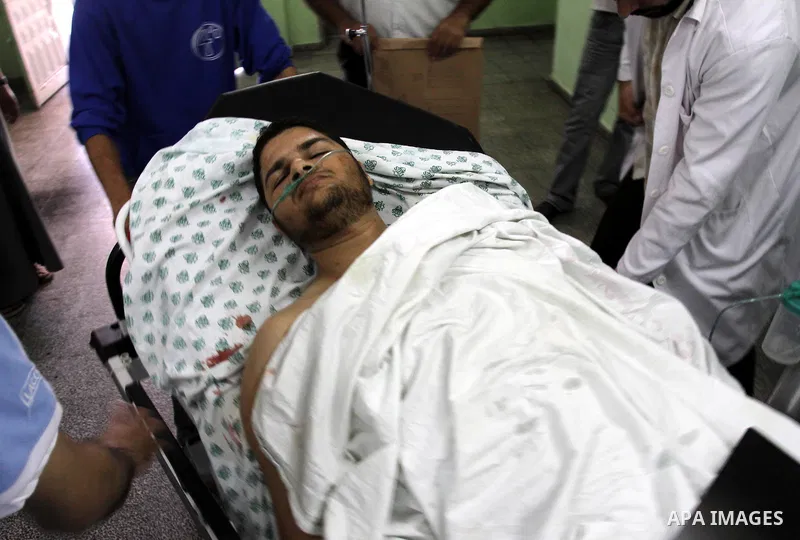 A Palestinian freelance photographer Mohammed Othman arrives to the hospital after he wounded when Israeli troops opened fire during on a massive march heading towards the Erez border crossing in the northern Gaza Strip,...