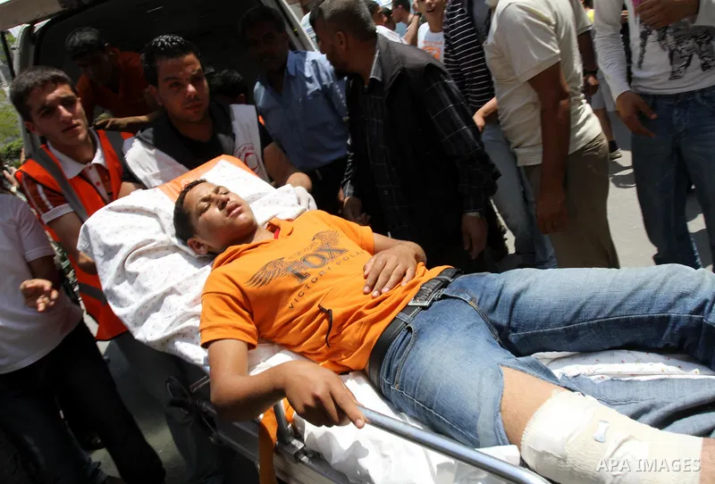 Palestinians carry a wounded protester after Israeli troops opened fire during a massive march heading towards the Erez border crossing in the northern Gaza Strip, on May 15, 2011, as people gathered to mark the "nakbah"...