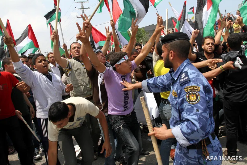 Palestinian protesters wave Palestinian national flags during a demonstration in front of the Erez border crossing in the northern Gaza Strip, on May 15, 2011, as people gathered to mark the "nakbah" or "catastrophe" ann...