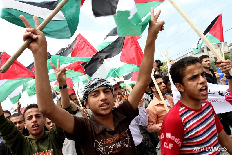 Palestinian protesters wave Palestinian national flags during a demonstration in front of the Erez border crossing in the northern Gaza Strip, on May 15, 2011, as people gathered to mark the "nakbah" or "catastrophe" ann...
