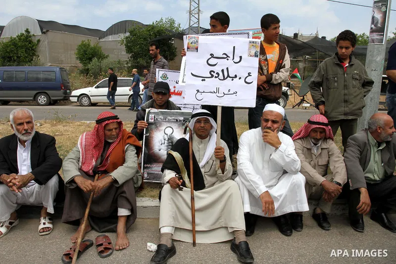 Palestinian protesters hold placards during a demonstration in front of the Erez border crossing in the northern Gaza Strip, on May 15, 2011, as people gathered to mark the "nakbah" or "catastrophe" anniversary of Israel...