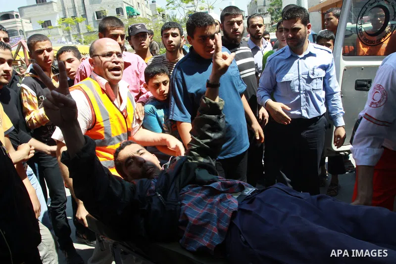Palestinians wheel a wounded protester after Israeli troops opened fire during a massive march heading towards the Erez border crossing in the northern Gaza Strip, on May 15, 2011, as people gathered to mark the "nakbah"...