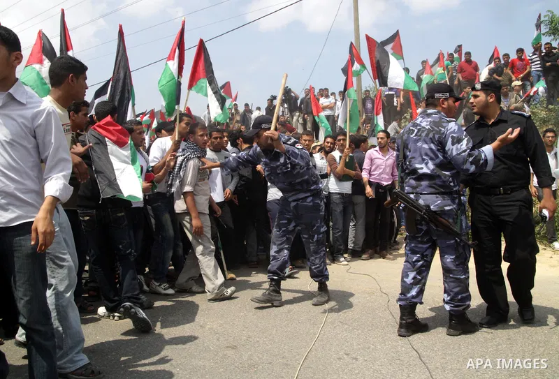 Members of Hamas' security forces holds back protesters from reaching Erez border crossing in the northern Gaza Strip, on May 15, 2011, as people gathered to mark the "nakbah" or "catastrophe" anniversary of Israel's cre...